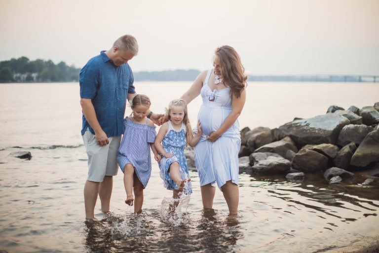 A family is playing in the water during their maternity session at Jonas and Anne Catharine Green Park in Maryland.