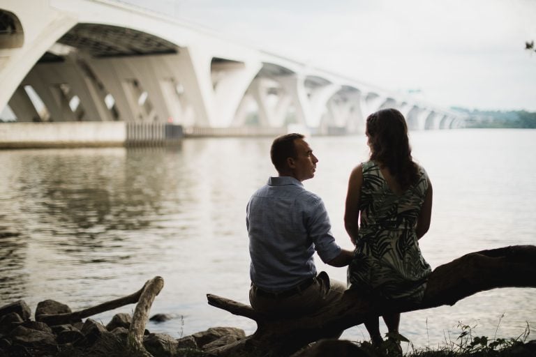 A couple sits on a log at Jones Point Park in Alexandria, Virginia.