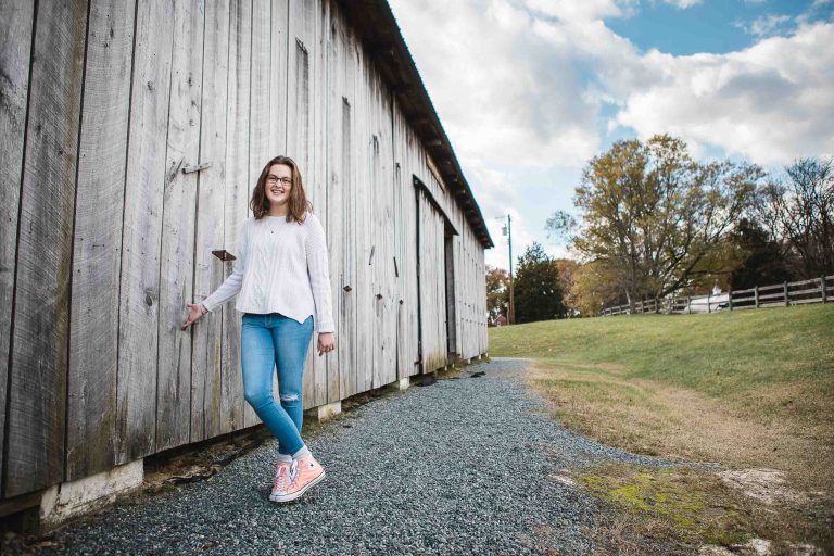 A young woman standing in front of a barn at Kinder Farm Park in Millersville, Maryland.