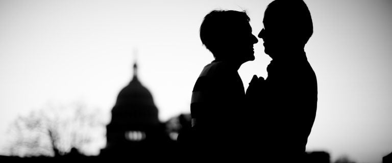 A silhouette of a couple kissing in front of the Library of Congress building in Washington DC.