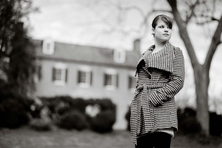 A black and white photo of a woman standing in front of the Marietta House.