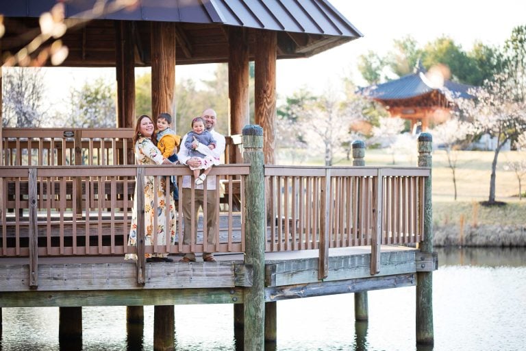 A family is standing on a gazebo at Meadowlark Botanical Gardens in Vienna, Virginia.