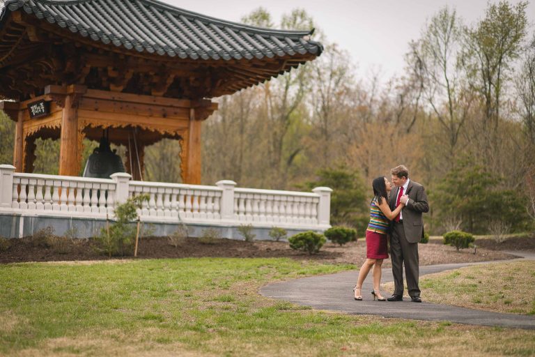 A couple kisses in front of a pagoda at Meadowlark Botanical Gardens.