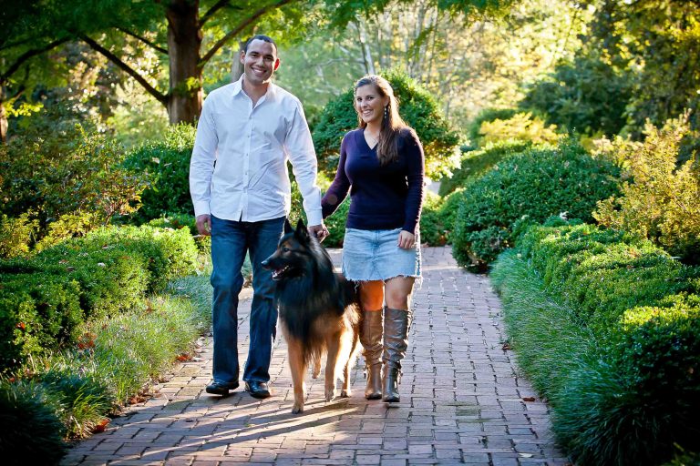 A man and woman walking their dog in the National Arboretum.