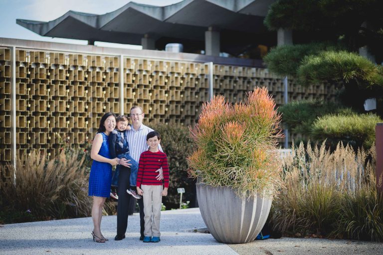 A family is posing for a photo in front of the National Arboretum in Washington DC.