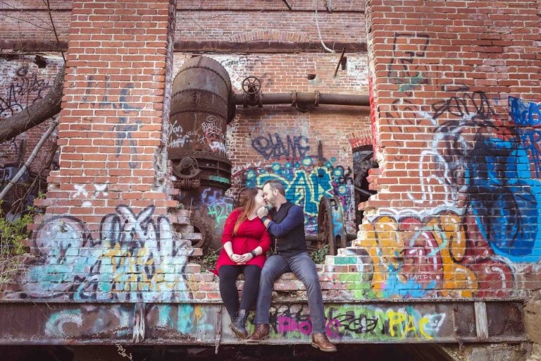 A couple sits in front of an old building at Historic Savage Mill.