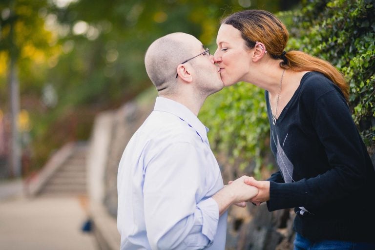 A couple kissing in front of a historic wall in Maryland.