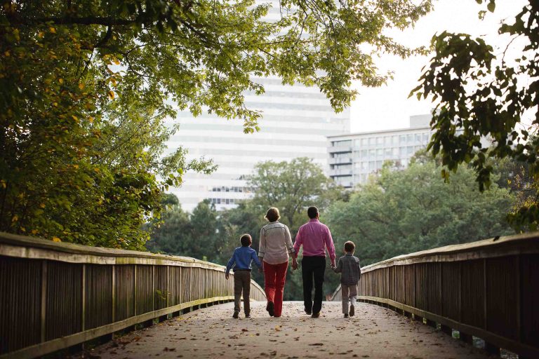 A family walking on a bridge in Theodore Roosevelt Island park.