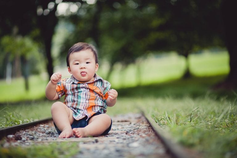 A baby sitting in Wheaton Regional Park.