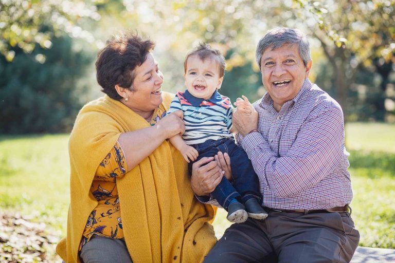 An older couple holding a baby in Fort McHenry Park.