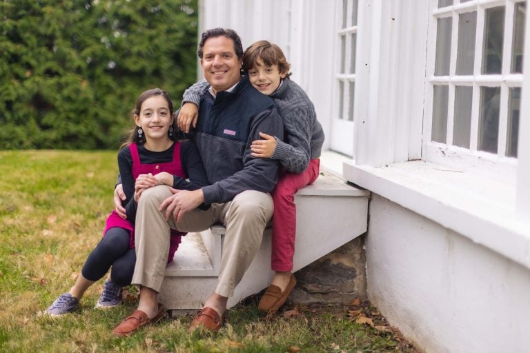 A man and two children sitting on the steps of Hampton Mansion in Maryland.