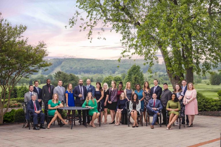 A group of people posing for a picture in front of a tree at Hayfields Country Club.