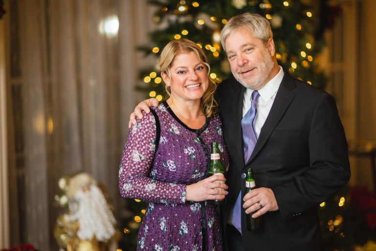 A man and woman posing in front of a Christmas tree at Hayfields Country Club in Hunt Valley, Maryland.