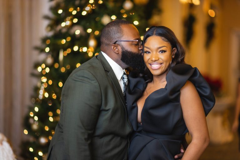 A man and woman hugging in front of a Christmas tree at Hayfields Country Club in Hunt Valley, Maryland.