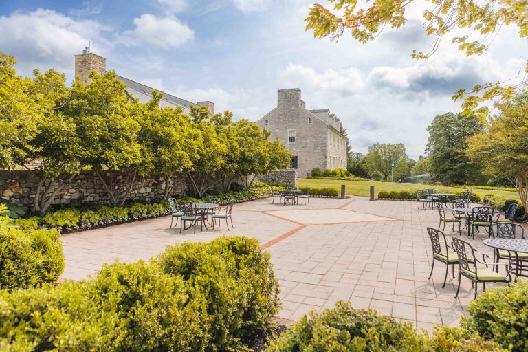 A courtyard with tables and chairs in front of Hayfields Country Club in Hunt Valley, Maryland.