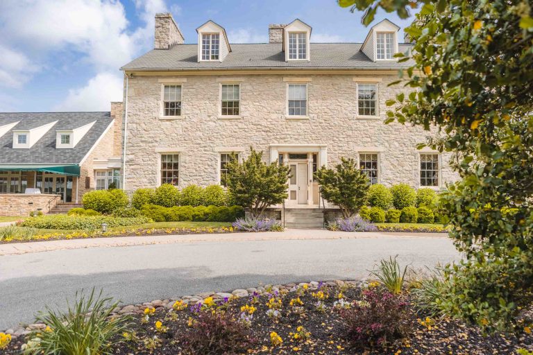 A large stone house in a residential neighborhood near Hayfields Country Club.