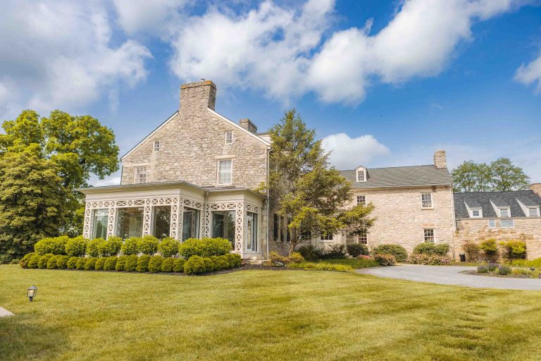 A stone mansion with a lawn and trees located in Hunt Valley, Maryland.