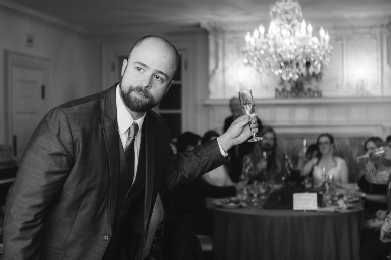 A man in a suit is holding a glass of wine at the Liriodendron Mansion in Bel Air, Maryland.