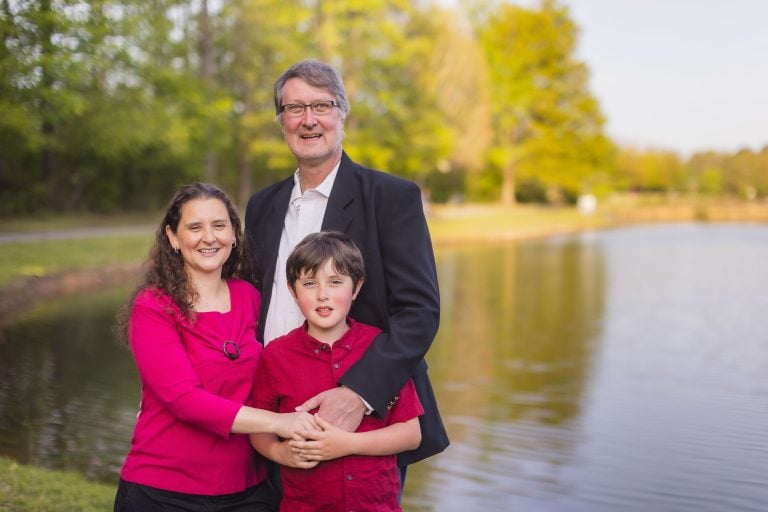 A family posing in front of Mill Branch Pond.