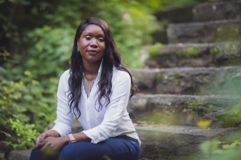 A black woman sitting on steps in the National Park Seminary Historic District.