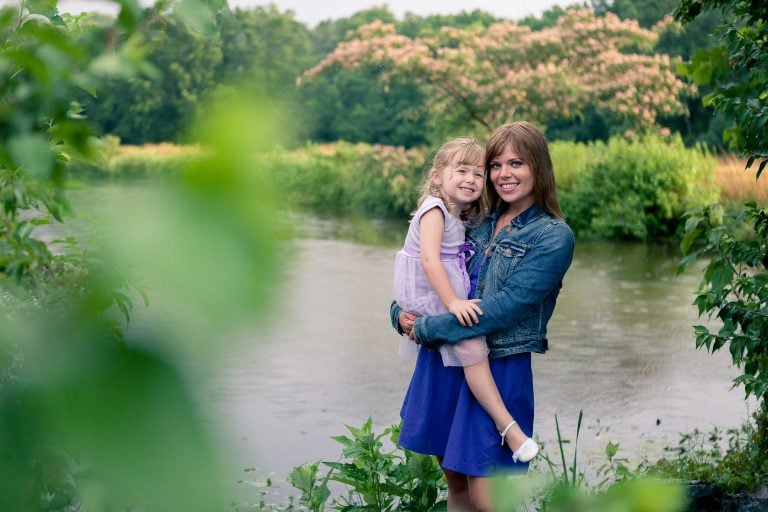 A woman is holding a little girl in front of the Patuxent Research Refuge in Maryland.