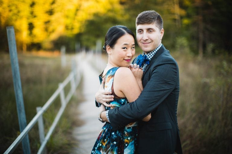 A man and woman hugging on a bridge in Patuxent Research Refuge, Laurel, Maryland.