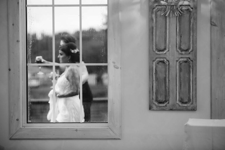 A wedding couple at Two Lions Vineyard in Maryland, Upper Marlboro, posing by a window.