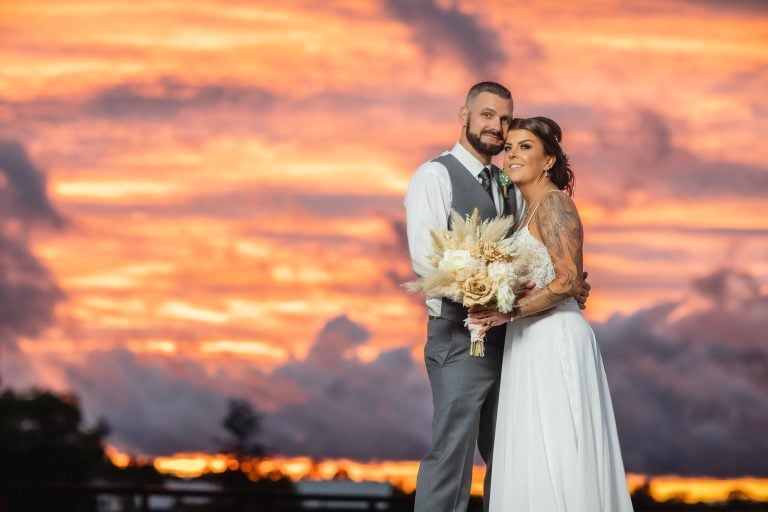 A bride and groom standing in front of a sunset at Two Lions Vineyard in Upper Marlboro, Maryland.