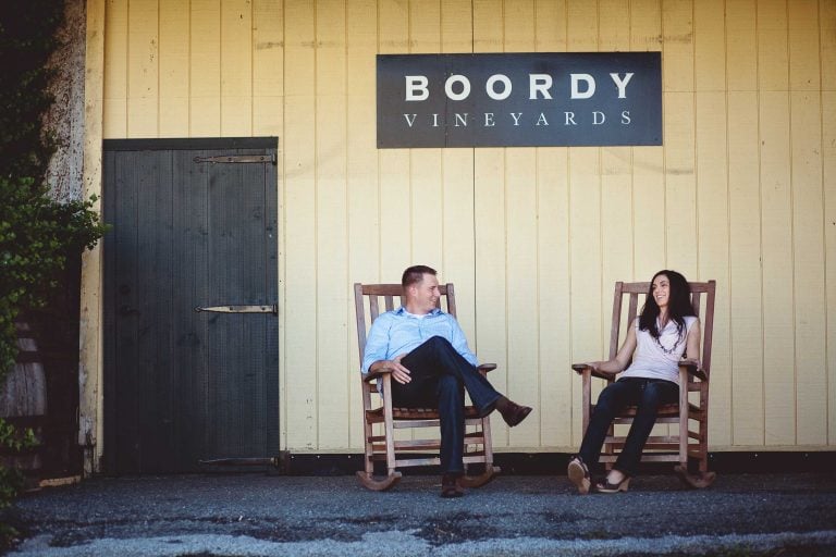 Two people sitting in rocking chairs in front of Boordy Vineyards in Maryland.