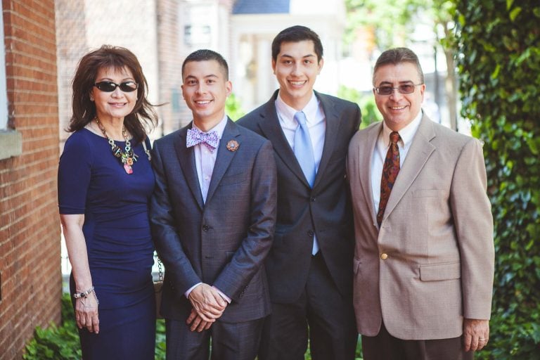 Four people posing for a picture in front of a brick wall in Maryland.