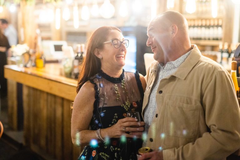 A couple smiling at each other at Great Frogs winery in Annapolis, Maryland.