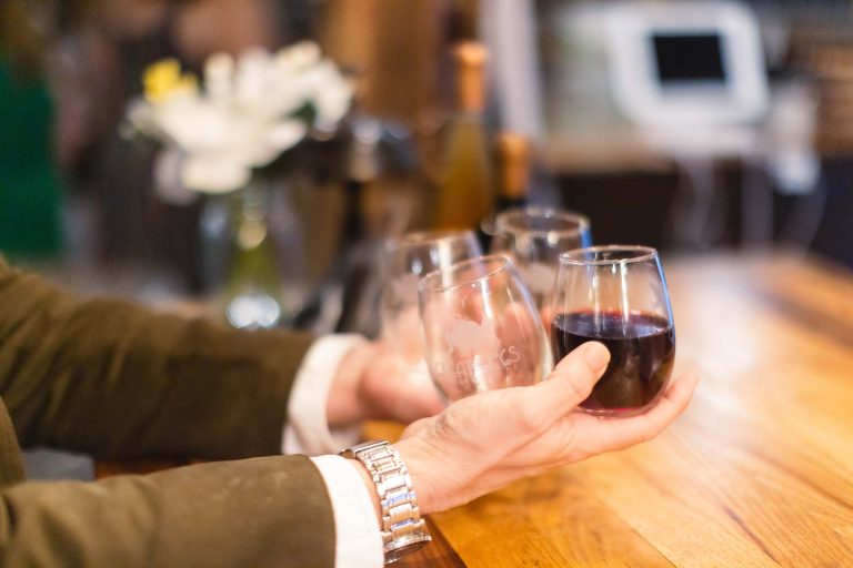 A man holding two glasses of wine at a bar in Annapolis, Maryland.