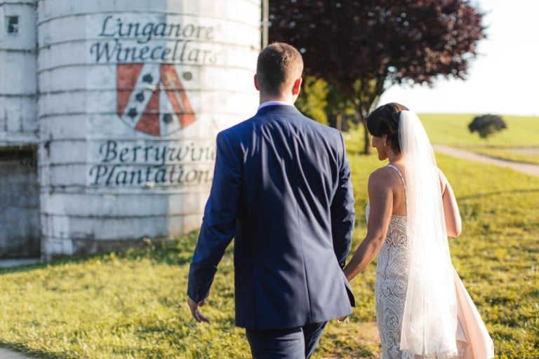 A bride and groom walking in front of a silo at Linganore Winecellars in Maryland, Mt. Airy.