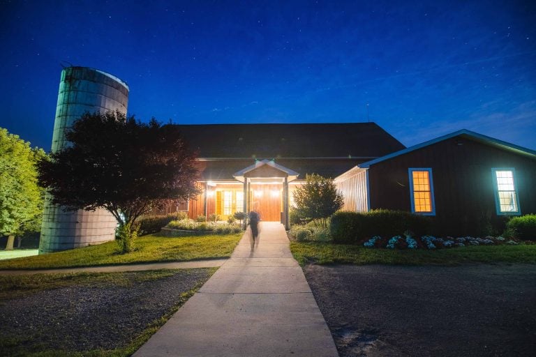 A man walks down a path to Linganore Winecellars at night.