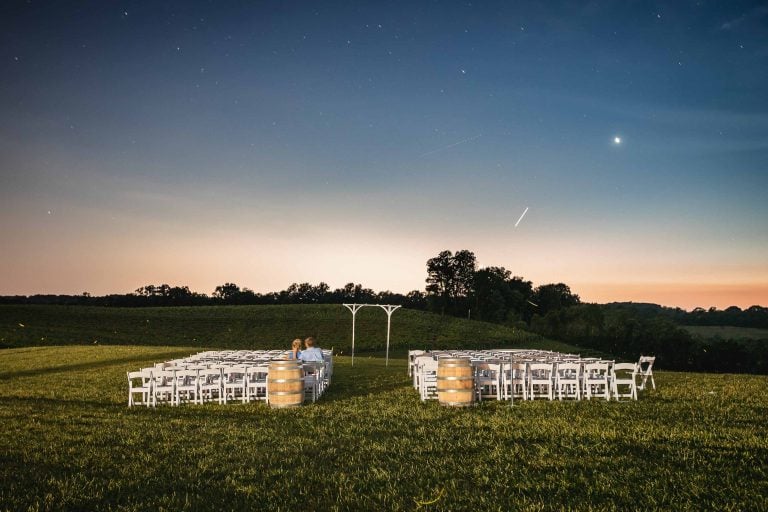 An enchanting wedding ceremony set up in the fields of Mt. Airy, Maryland, under a starry sky.