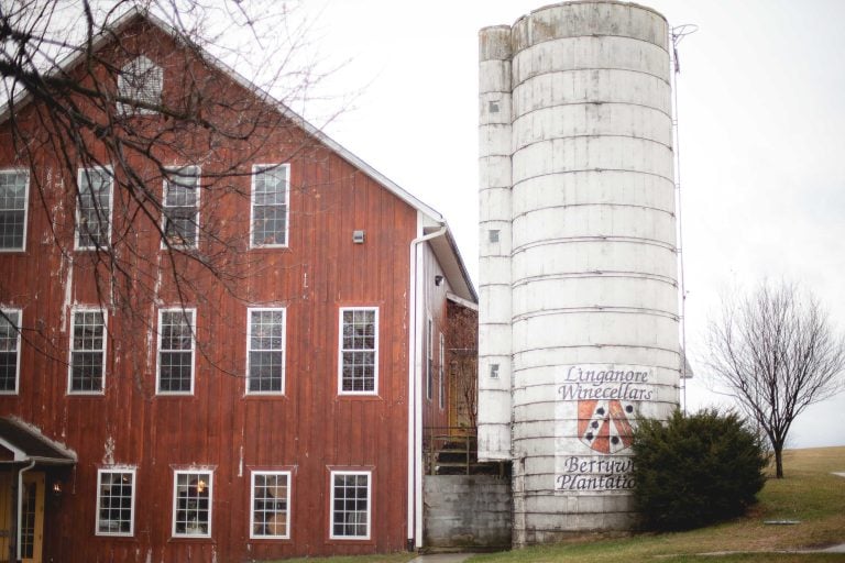 A red barn with a silo in front of it located in Maryland.