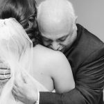 A candid black and white photo of a bride hugging her father on her wedding day at Fleetwood Farm Winery.