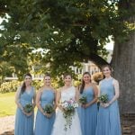 A wedding portrait at Fleetwood Farm Winery, with the bride and her bridesmaids posing in front of a tree.