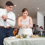 A bride and groom cutting their wedding cake at the reception held at Fleetwood Farm Winery.