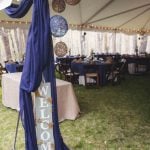 A detailed blue tent with a welcome sign for a wedding.