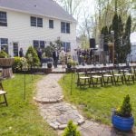 A detailed wedding ceremony setup in a house yard.