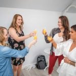 Bridesmaids candidly preparing for the wedding in the bridal room.