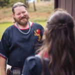 A man in a medieval costume is candidly preparing for a wedding conversation with a woman.