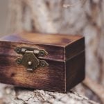 A small wooden box sitting on top of a tree branch with intricate details.