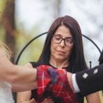 A man is putting a kilt on a woman's hand during a wedding ceremony.