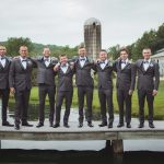 A portrait of groomsmen on a dock at a wedding.