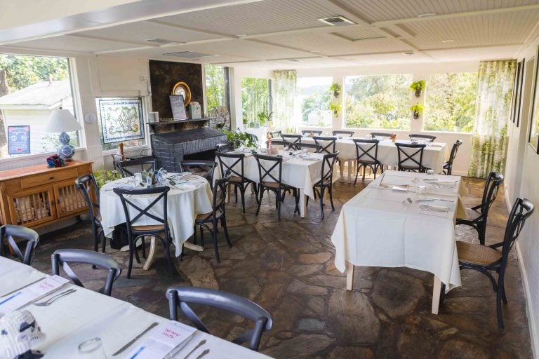 A wedding reception with tables and chairs set up in the dining room.