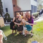 A group of bridesmaids posing for a photo at a wedding reception in front of a VW van.