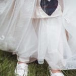 A bride in a white dress with a heart on her shoe.