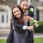 A man is carrying a bride on his shoulders during their wedding.